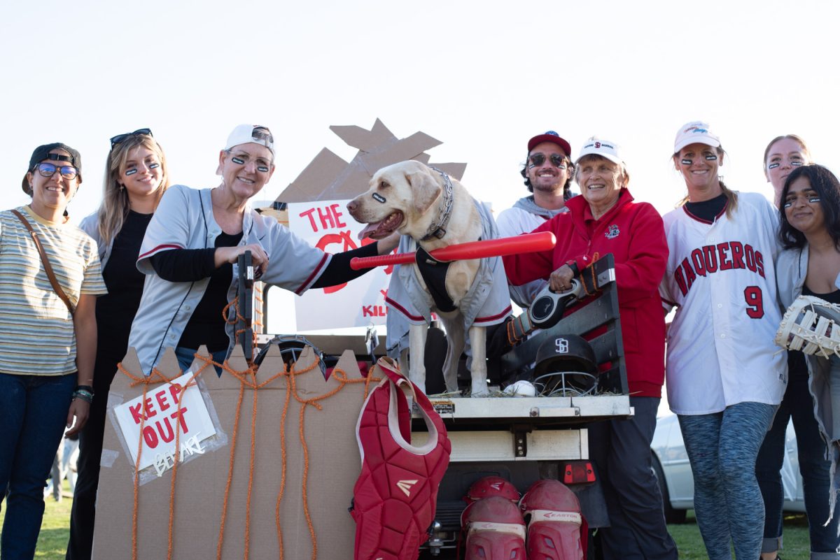 File photo of members of the City College Athletics Department line up at their Sandlot themed tailgate on Oct. 27, 2022, at the West Campus Great Meadow in Santa Barbara, Calif. Their trunk display was supported by loyal mascot, Max the Dog, seen center frame wearing a red bat and baseball jersey.